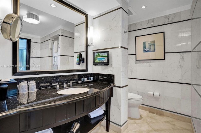 bathroom with tile walls, vanity, and toilet