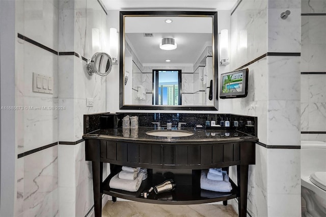 bathroom with vanity, tile walls, and toilet