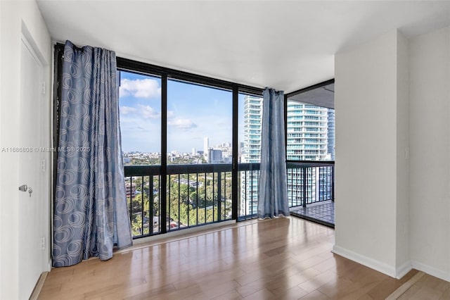 spare room featuring hardwood / wood-style flooring and a wall of windows