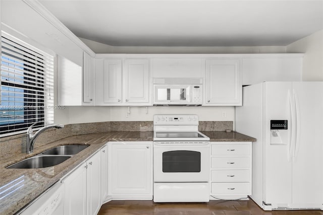 kitchen with white appliances, white cabinetry, dark stone countertops, and sink