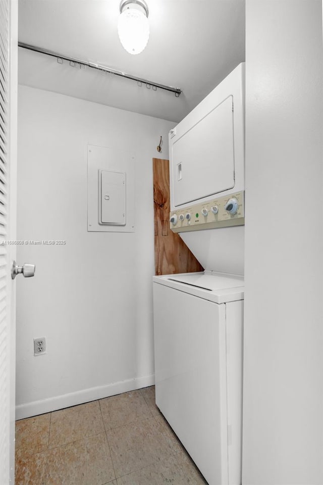 laundry room with electric panel and stacked washer / dryer