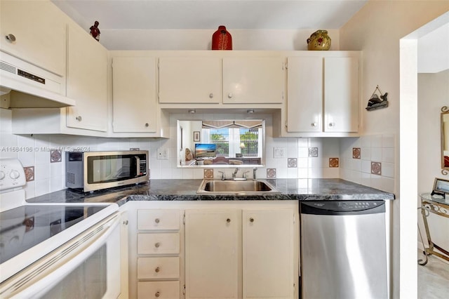 kitchen featuring tasteful backsplash, range hood, sink, cream cabinetry, and stainless steel appliances