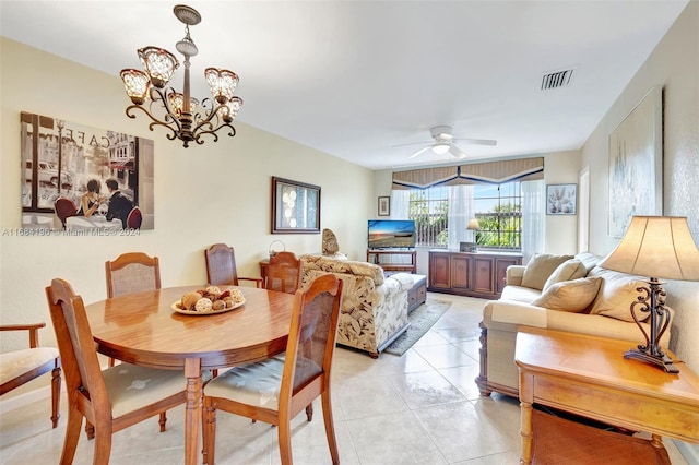 tiled dining room with ceiling fan with notable chandelier