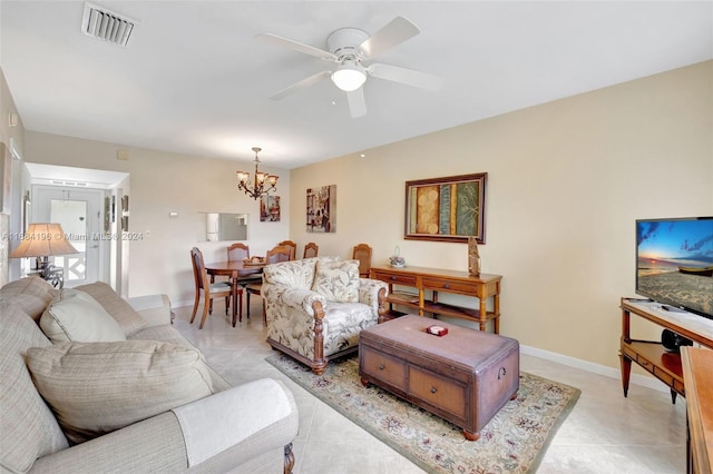 living room with light tile patterned flooring and ceiling fan with notable chandelier