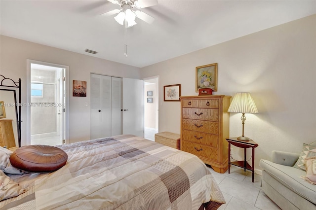 bedroom with ensuite bath, light tile patterned flooring, a closet, and ceiling fan