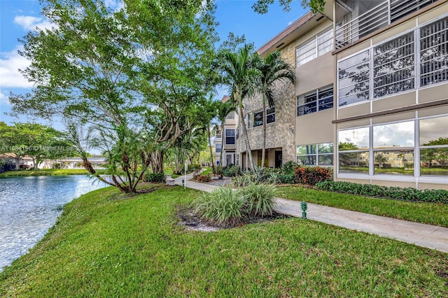 view of community featuring a lawn and a water view