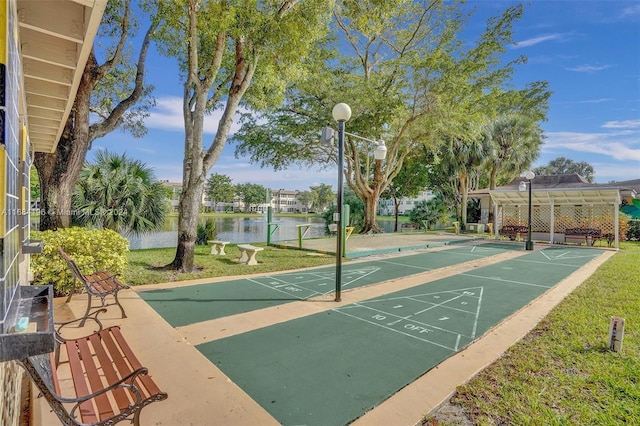 view of home's community with a water view and a lawn