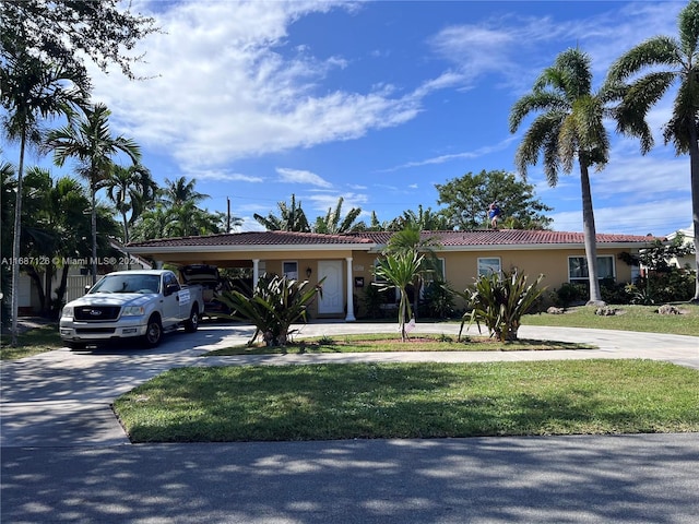 ranch-style home with a carport and a front lawn