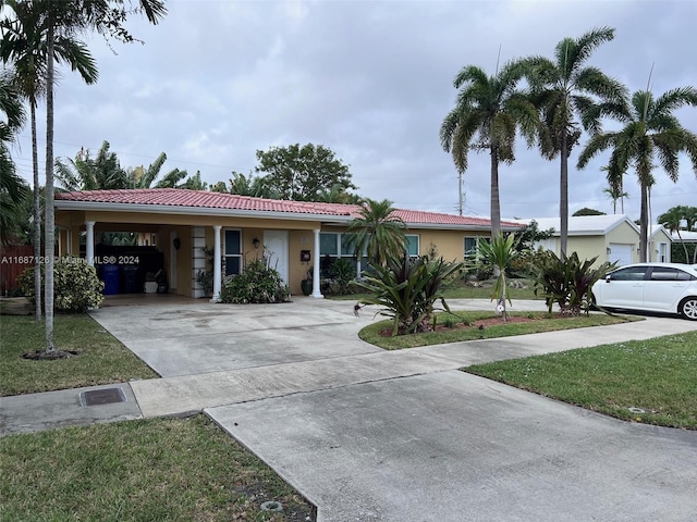 view of front of home with a carport and a front lawn