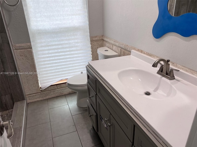 bathroom with tile patterned flooring, vanity, and toilet