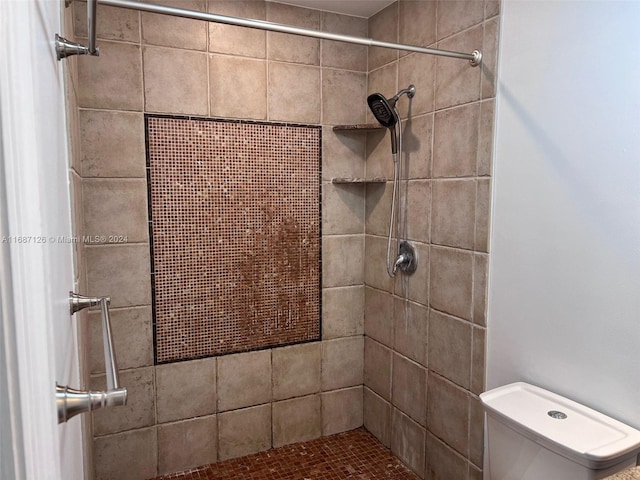 bathroom with toilet and a tile shower