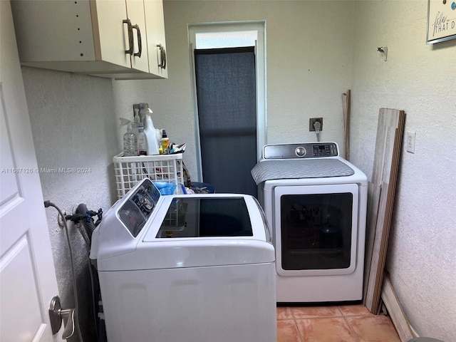 washroom featuring cabinets, independent washer and dryer, and light tile patterned flooring