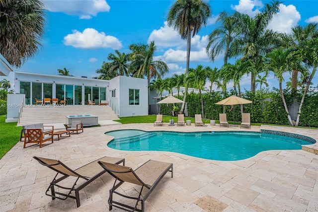 view of swimming pool with a patio and a hot tub