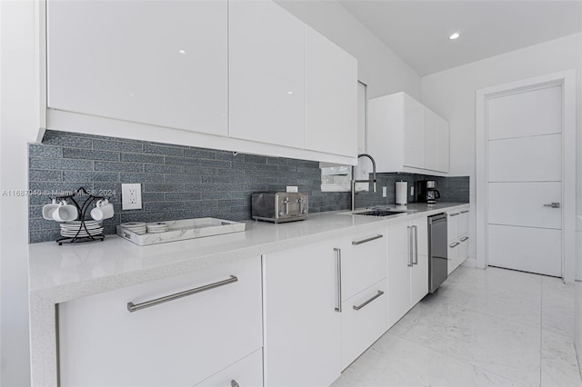 kitchen featuring backsplash, dishwasher, white cabinets, and sink