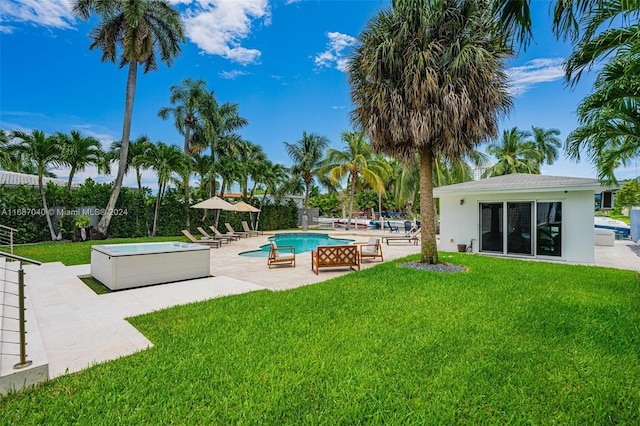 view of pool featuring a lawn, a patio area, and a jacuzzi