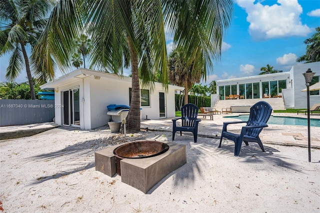 view of patio featuring a fenced in pool and a fire pit