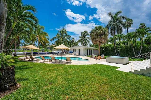 view of swimming pool featuring a lawn, a patio area, and a hot tub