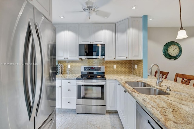 kitchen with stainless steel appliances, sink, a breakfast bar area, decorative light fixtures, and white cabinets