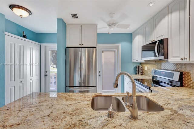 kitchen with white cabinetry, kitchen peninsula, and appliances with stainless steel finishes