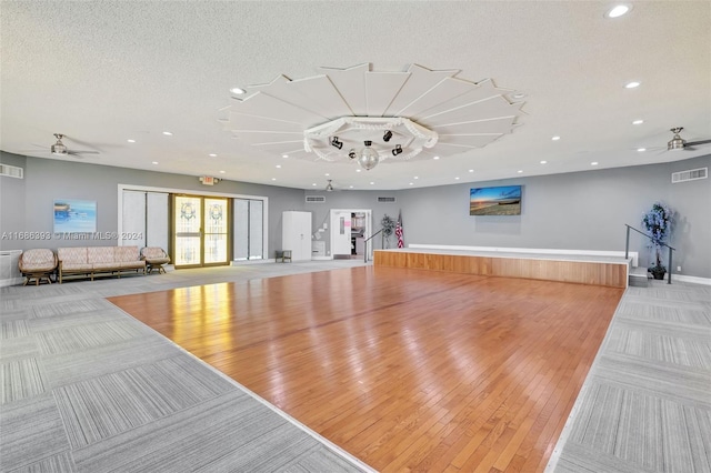 exercise area featuring a textured ceiling and light hardwood / wood-style flooring