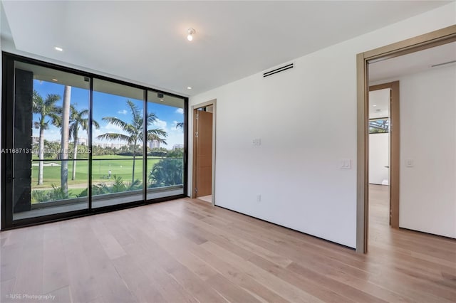 spare room with light hardwood / wood-style flooring and expansive windows