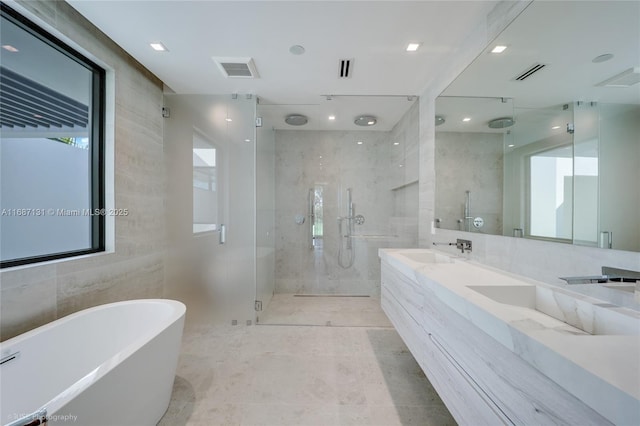 bathroom with vanity, shower with separate bathtub, and tile walls