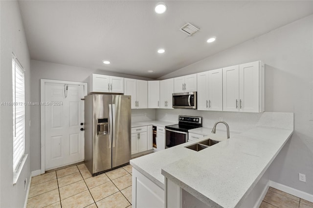 kitchen featuring kitchen peninsula, appliances with stainless steel finishes, sink, light tile patterned floors, and white cabinets