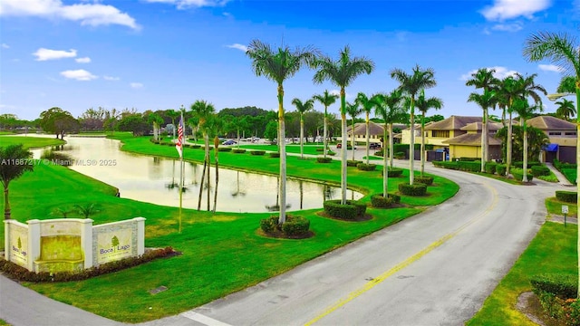 view of community with a yard and a water view