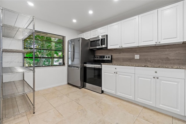 kitchen featuring backsplash, dark stone counters, stainless steel appliances, white cabinetry, and light tile patterned flooring