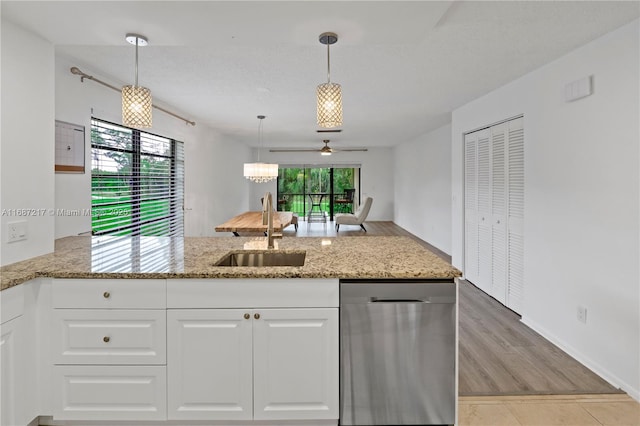 kitchen featuring stainless steel dishwasher, decorative light fixtures, white cabinetry, and sink