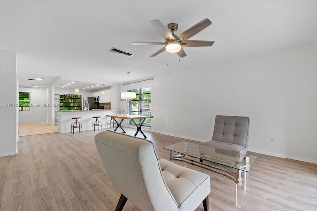 living area featuring ceiling fan and light wood-type flooring