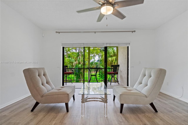 sitting room with light wood-type flooring and ceiling fan