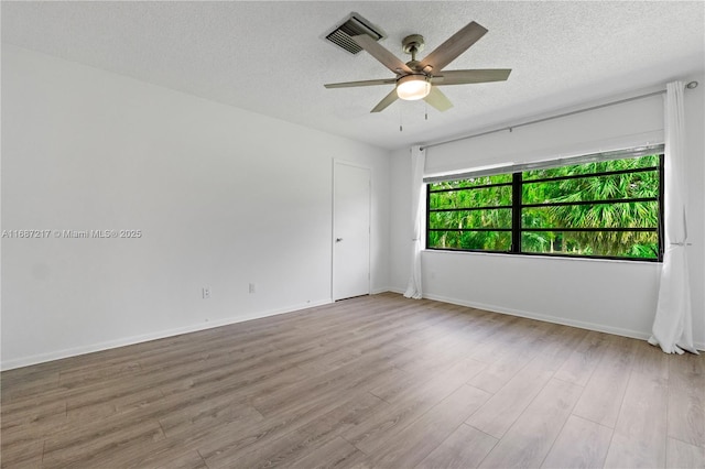 unfurnished room with ceiling fan, light hardwood / wood-style floors, and a textured ceiling