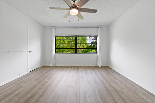 unfurnished room with ceiling fan, light hardwood / wood-style floors, and a textured ceiling