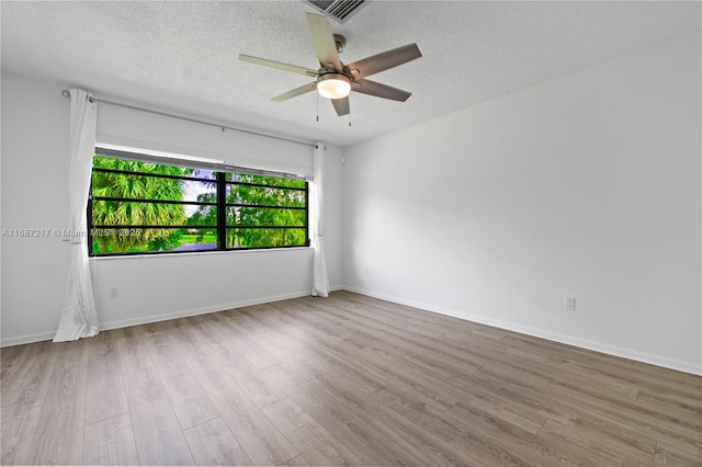 spare room featuring a textured ceiling, light hardwood / wood-style flooring, and ceiling fan