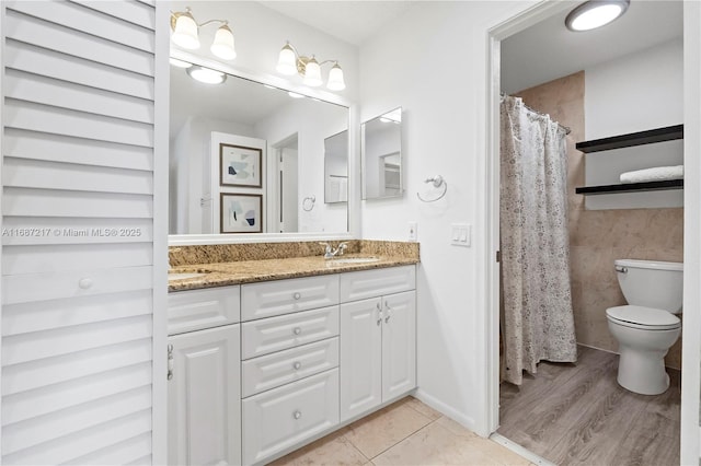 bathroom with tile patterned floors, vanity, tile walls, and toilet