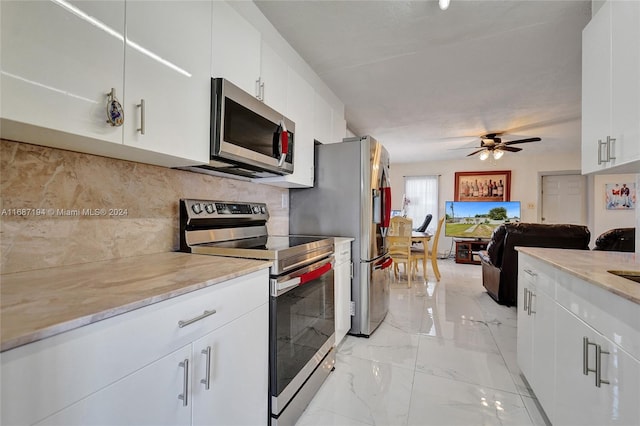 kitchen with appliances with stainless steel finishes, white cabinetry, tasteful backsplash, and ceiling fan