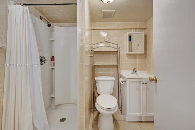 bathroom featuring curtained shower, toilet, tile patterned floors, tile walls, and vanity