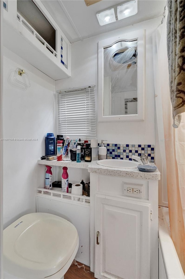 bathroom featuring toilet, hardwood / wood-style floors, and vanity