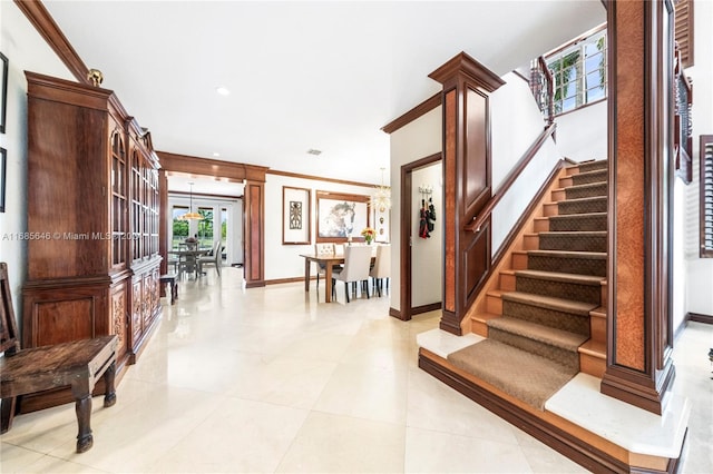 stairs featuring tile patterned floors, decorative columns, and ornamental molding