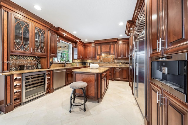 kitchen featuring backsplash, a center island, stainless steel appliances, beverage cooler, and a breakfast bar