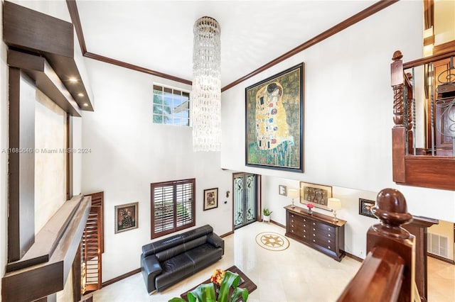 living area featuring crown molding, a healthy amount of sunlight, and a chandelier