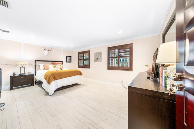 bedroom featuring light hardwood / wood-style floors and crown molding