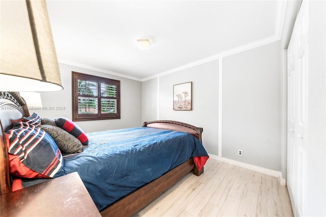 bedroom featuring light hardwood / wood-style floors and crown molding