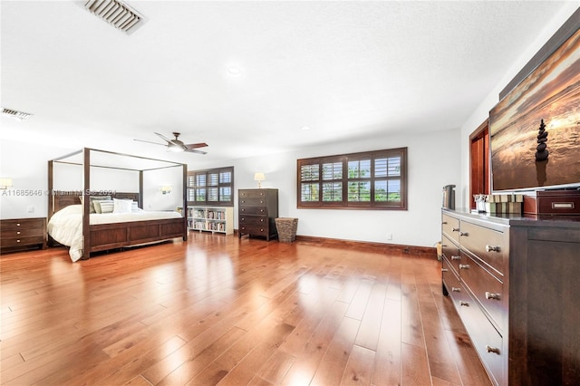 bedroom with multiple windows, light wood-type flooring, and ceiling fan