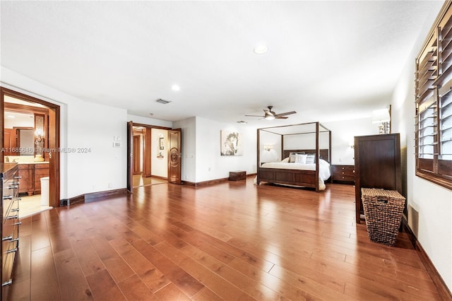 unfurnished bedroom with ceiling fan, hardwood / wood-style flooring, and ensuite bath