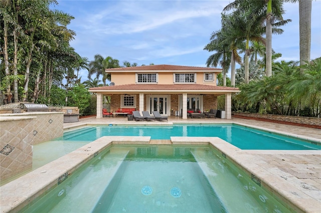 view of pool featuring outdoor lounge area, an in ground hot tub, and a patio