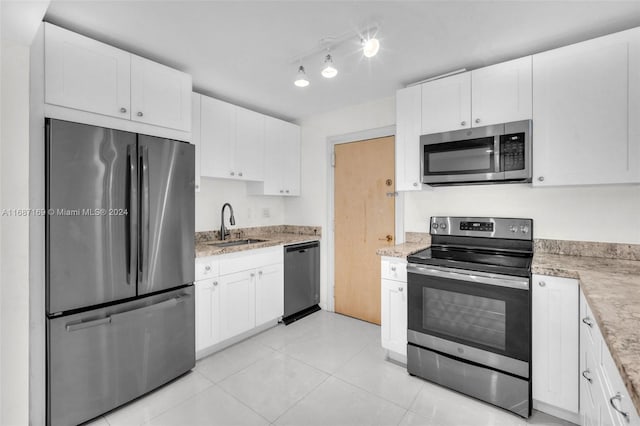 kitchen with white cabinetry, appliances with stainless steel finishes, sink, and light tile patterned floors