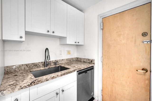 kitchen featuring light stone countertops, white cabinetry, sink, and dishwasher