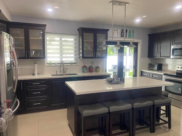 kitchen featuring appliances with stainless steel finishes, a center island, sink, and plenty of natural light